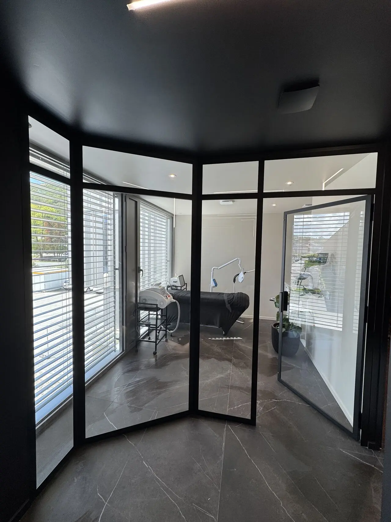 Cloison vitrée d’angle à profils noirs dans un intérieur.